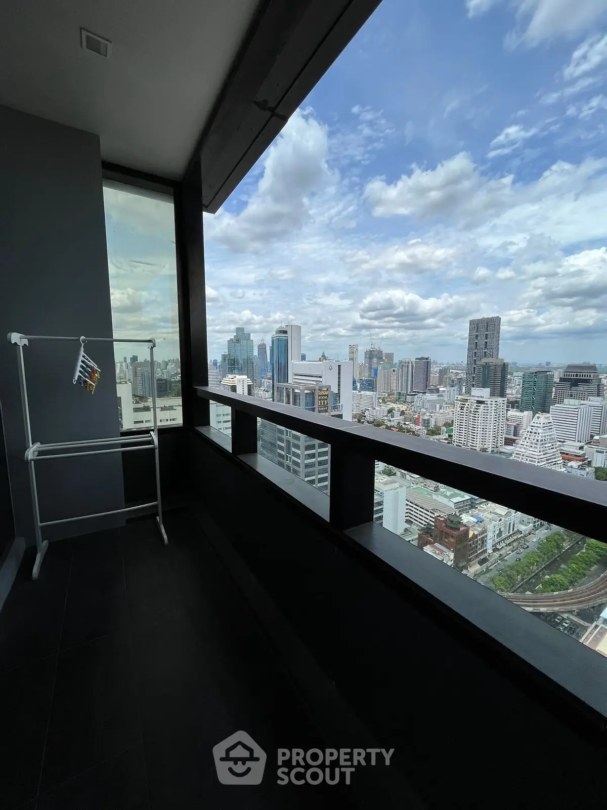 Stunning cityscape view from high-rise balcony with modern railing.