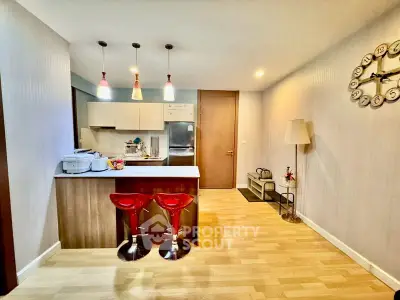 Modern kitchen with open layout and stylish bar stools in a cozy apartment setting.