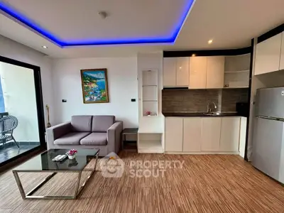 Modern living room with sleek kitchen and balcony access, featuring stylish lighting and contemporary decor.