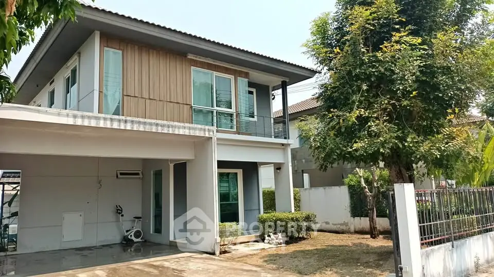 Modern two-story house with spacious driveway and lush greenery