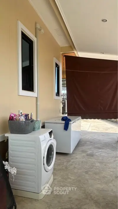 Spacious outdoor laundry area with washing machine and freezer, perfect for modern living convenience.