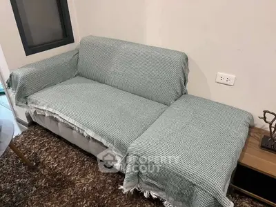 Cozy living room with a covered sofa and modern decor, perfect for relaxation.