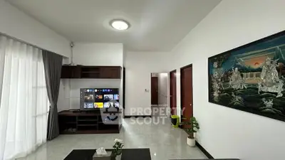 Spacious living room with modern decor and entertainment center in a bright, airy apartment.