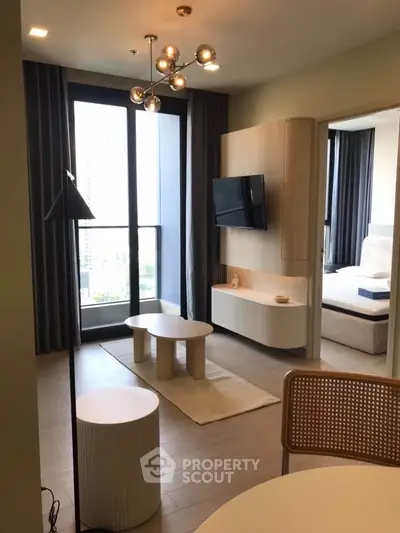 Modern living room with stylish furniture and large window offering city views