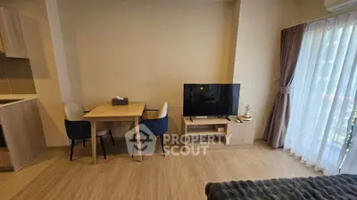 Modern living room with cozy dining area and large TV, featuring elegant wooden flooring and natural light.