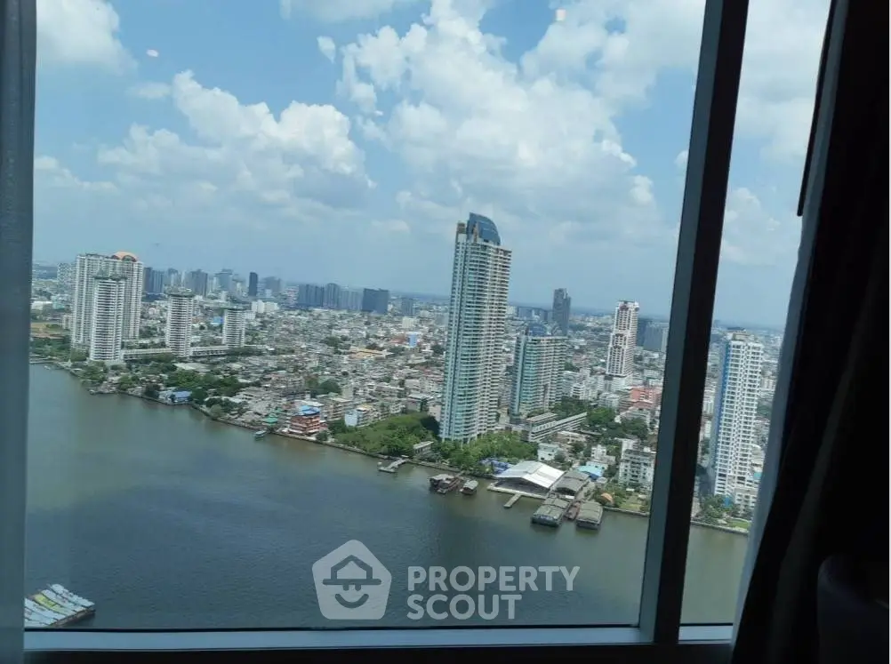 Stunning cityscape view from high-rise window overlooking river and skyline.