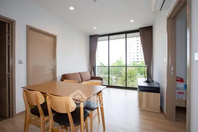 Modern living room with large windows and balcony view in a stylish apartment.