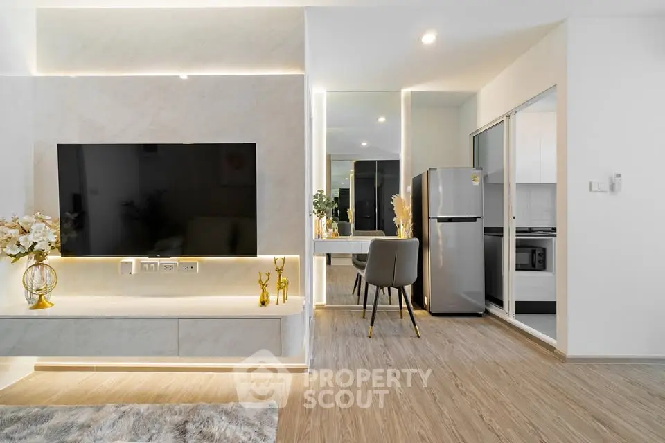 Modern living room with sleek TV setup and stylish kitchen area