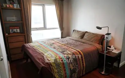 Cozy bedroom with colorful bedding and natural light from large window