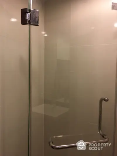 Modern bathroom with sleek glass shower door and chrome handle