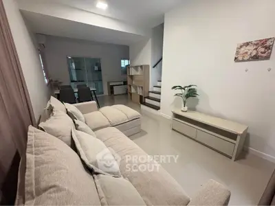 Spacious living room with modern decor and cozy seating in a stylish home.