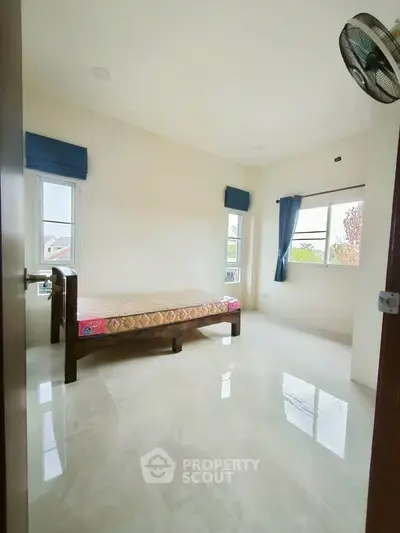 Spacious bedroom with large windows and natural light