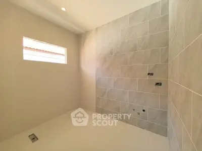 Spacious modern bathroom with elegant tile design and natural light.