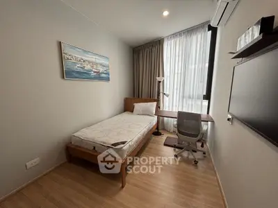 Modern minimalist bedroom with single bed, study desk, and large window