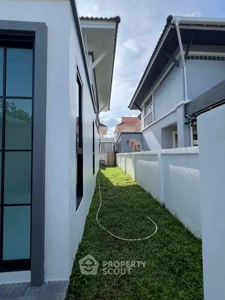 Charming side garden view of modern suburban homes with lush greenery.