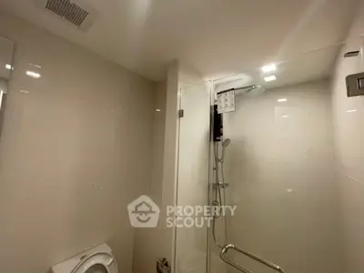 Modern bathroom with glass shower and sleek fixtures in a contemporary apartment.