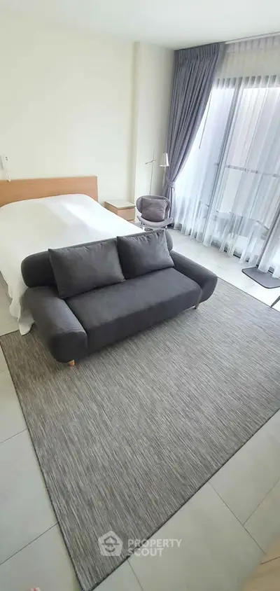 Spacious bedroom with modern decor and large window for natural light