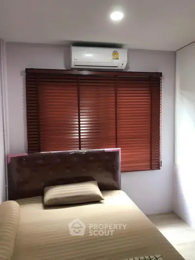 Cozy bedroom with air conditioning and stylish blinds, perfect for relaxation.