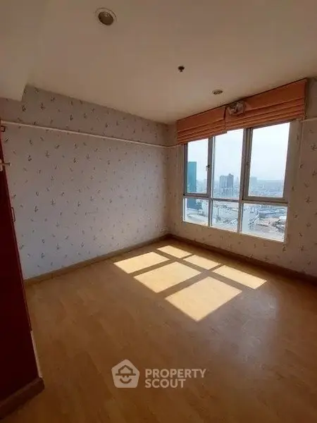 Bright empty room with large windows and city view, perfect for customization.