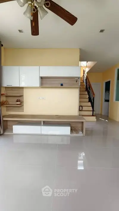 Spacious living room with modern built-in storage and staircase