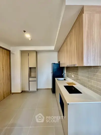 Modern kitchen with sleek cabinetry and built-in appliances in a contemporary apartment.