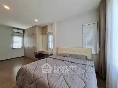 Spacious modern bedroom with elegant decor and ample natural light