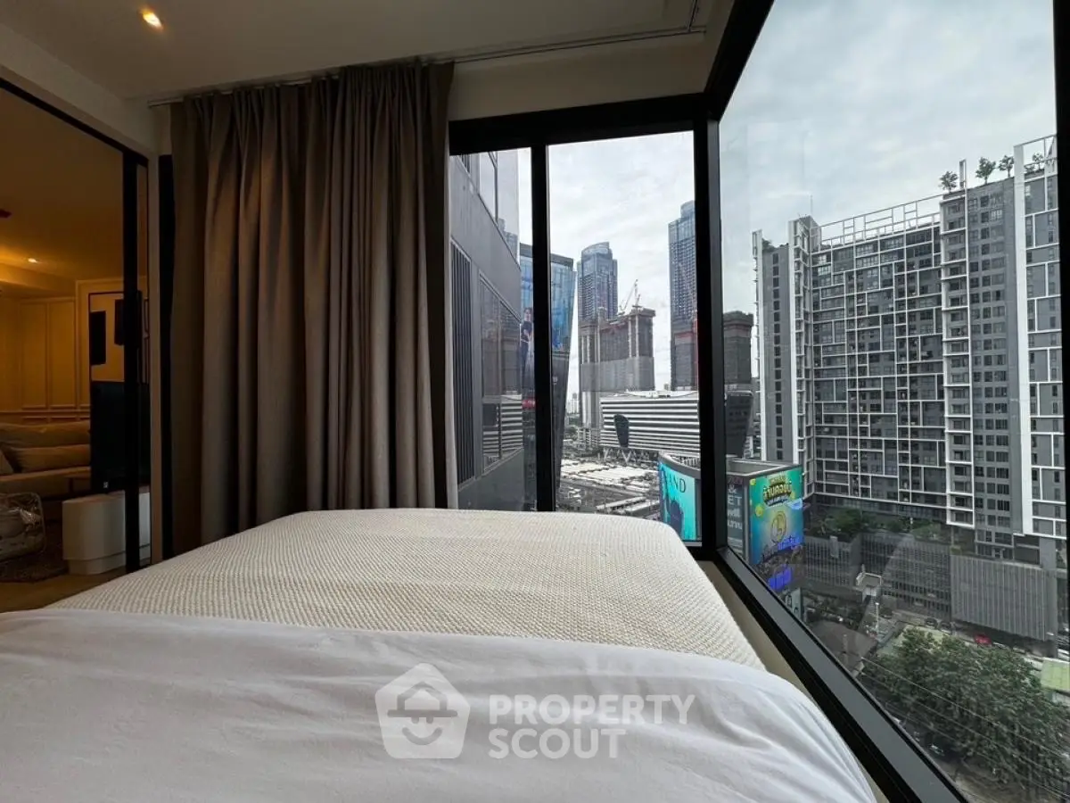 Modern bedroom with stunning city view from large windows in a high-rise building.