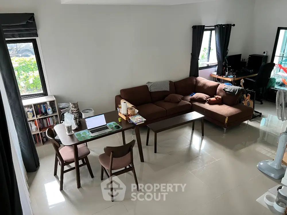 Spacious living room with modern furniture and natural light, perfect for relaxation and work-from-home setup.