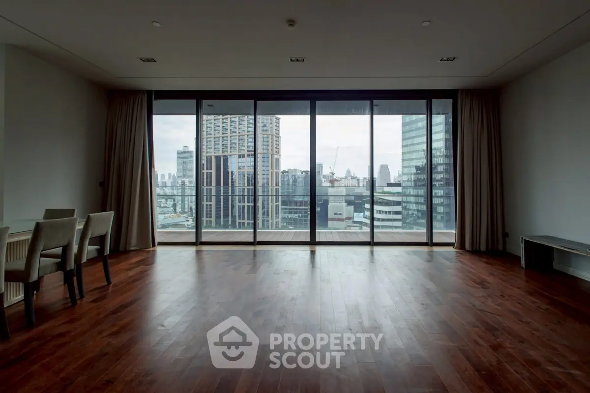 Spacious living room with floor-to-ceiling windows offering stunning city views.