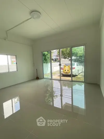 Spacious empty room with large windows and glossy tiled floor, perfect for customization.