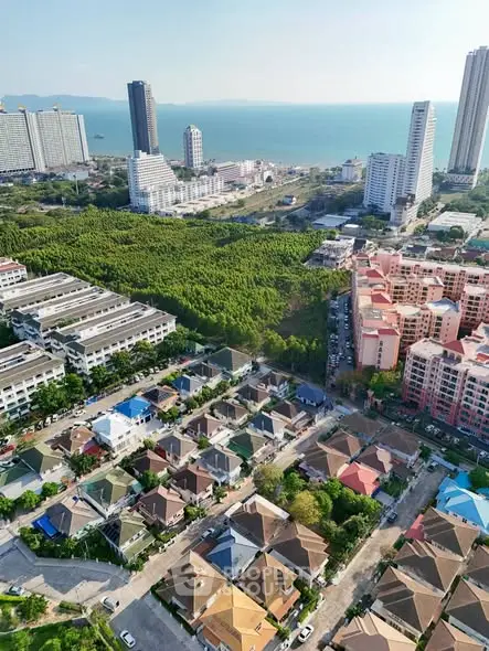 Aerial view of coastal residential area with high-rise buildings and ocean backdrop.