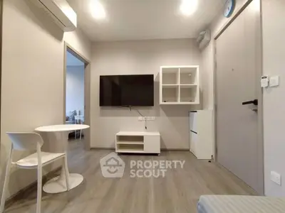 Modern living room with minimalist furniture and wall-mounted TV in a cozy apartment.