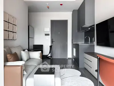 Modern living room with sleek kitchen, stylish furniture, and contemporary decor in a compact apartment.