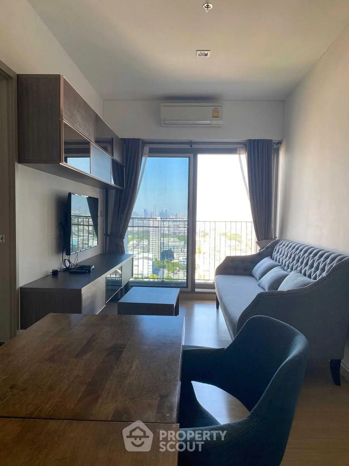 Modern living room with city view, stylish furniture, and natural light.