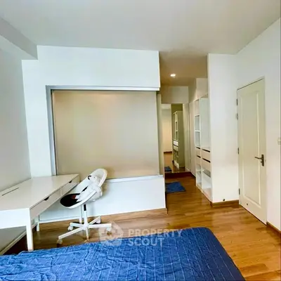 Modern bedroom with study area and wooden flooring