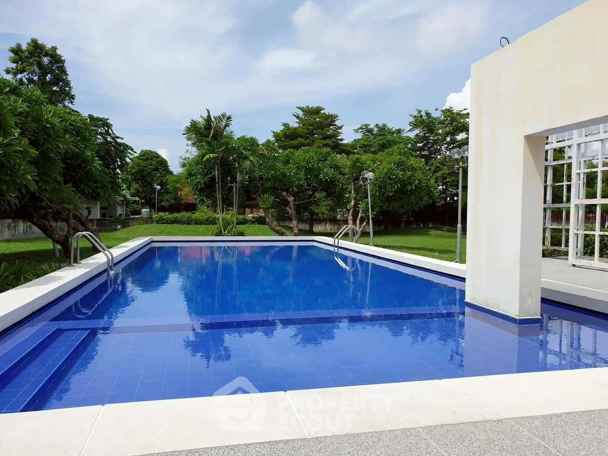 Luxurious outdoor pool with lush greenery and modern design, perfect for relaxation and leisure.