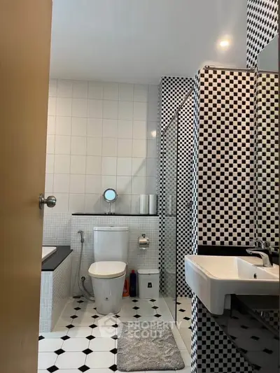 Stylish black and white checkered bathroom with modern fixtures and elegant design.