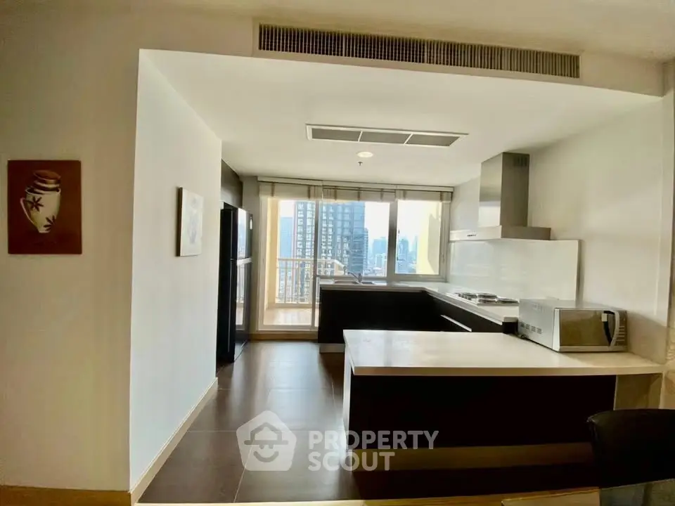 Modern kitchen with open layout and city view, featuring sleek appliances and stylish design.