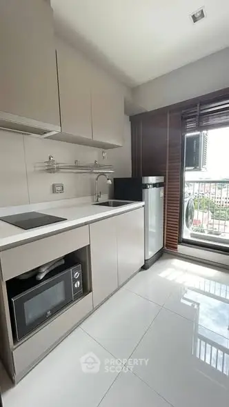 Modern kitchen with sleek appliances and balcony view