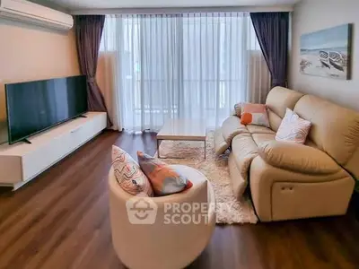 Spacious living room with modern furniture and large TV, perfect for relaxation.