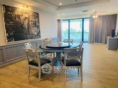 Spacious living room with elegant dining area and large windows offering natural light.