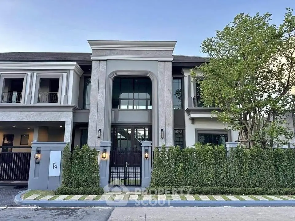 Luxurious modern two-story house with elegant facade and lush greenery