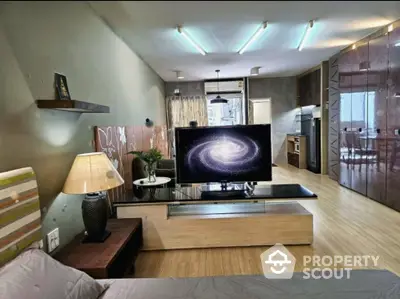 Modern open layout living room with stylish decor and large TV, perfect for entertainment.