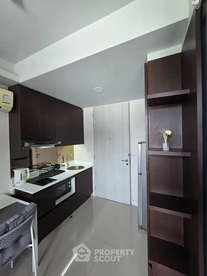 Modern kitchen with sleek cabinetry and gas stove in a compact apartment