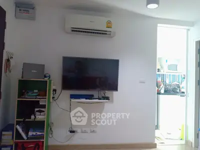Modern living room with wall-mounted TV and air conditioning unit, showcasing a cozy and functional space.