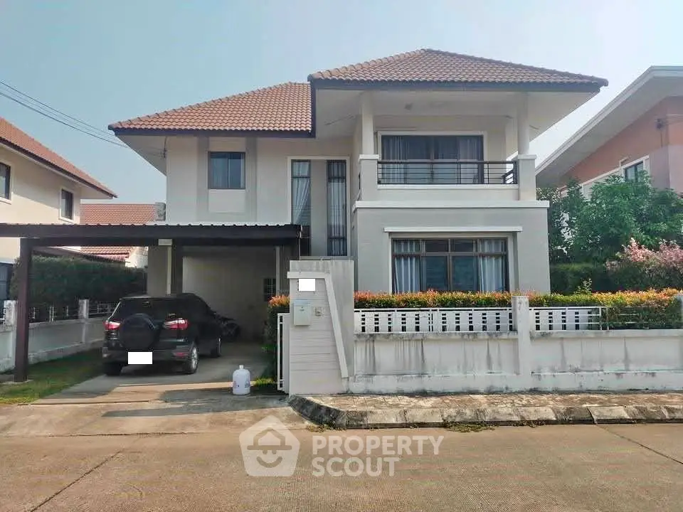 Charming two-story house with carport and manicured garden in a serene neighborhood.