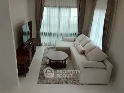 Modern living room with cozy white sofa and large windows