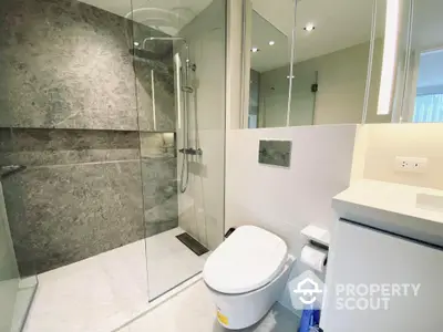 Modern bathroom with glass shower enclosure, sleek fixtures, and neutral color palette, offering a clean and contemporary space for relaxation.