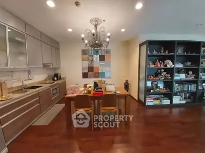 Chic dining area with modern kitchen and stylish chandelier in cozy apartment.
