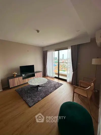 Spacious living room with modern decor and city view balcony.